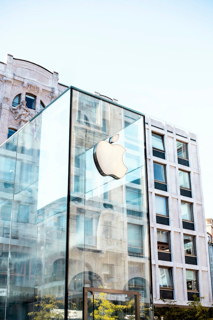 Facade of a modern glass building featuring the iconic Apple logo in Milano, Italy.