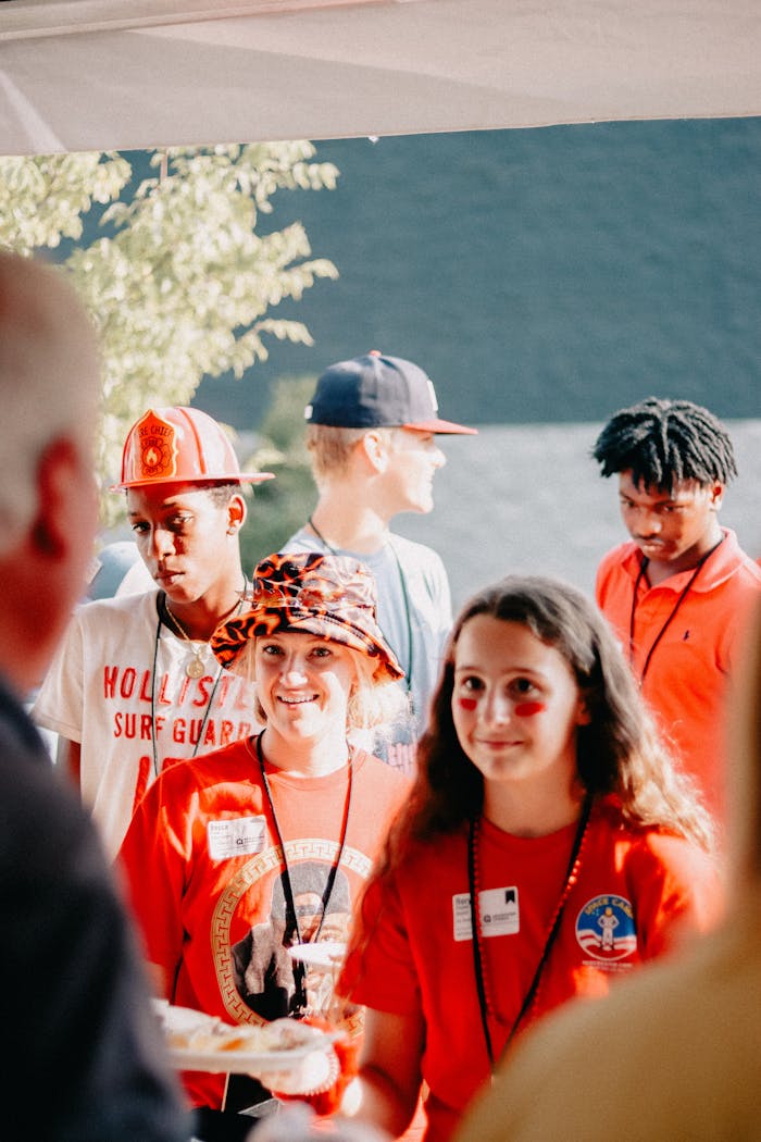 A cheerful church community gathers outdoors for a fellowship event, enjoying food and company.