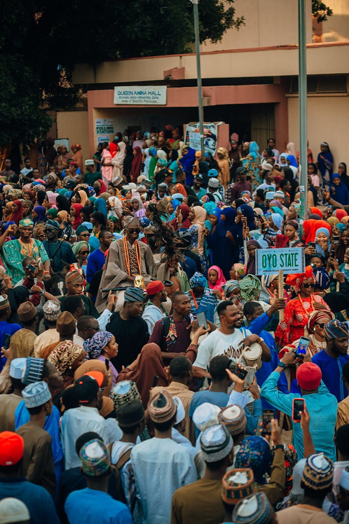 A vibrant crowd participates in a lively street festival in Oyo State, Nigeria.