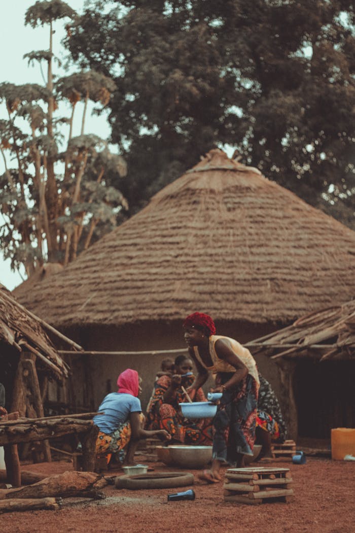 A vibrant scene of daily life in an African village with traditional huts and community activities.